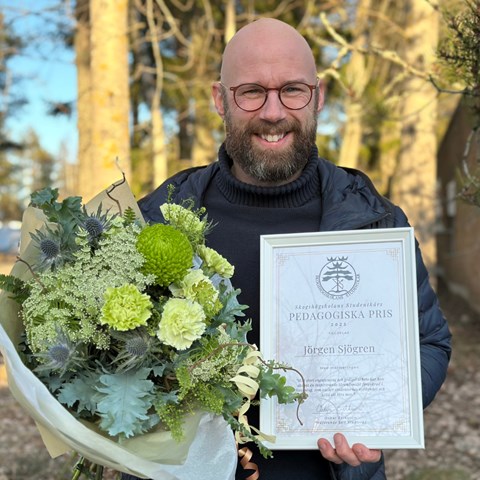 man med diplom och blommor