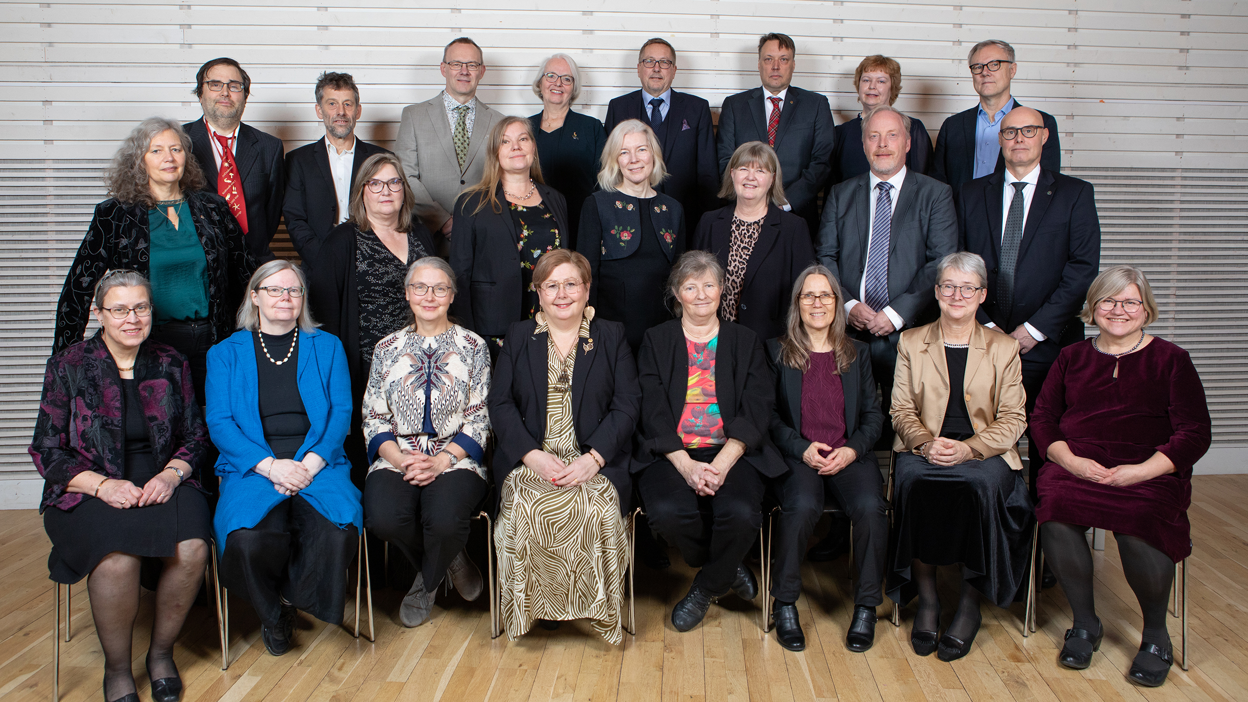 En uppställd gruppbild av glada människor. Totalt 23 personer.