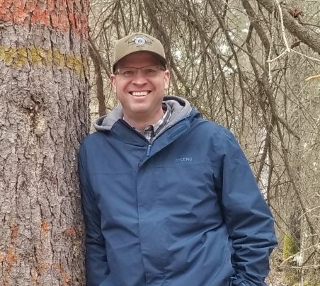 Man standing next to a tree