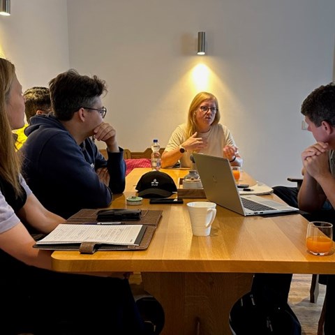 Grupp av människor diskuterar runt ett bord