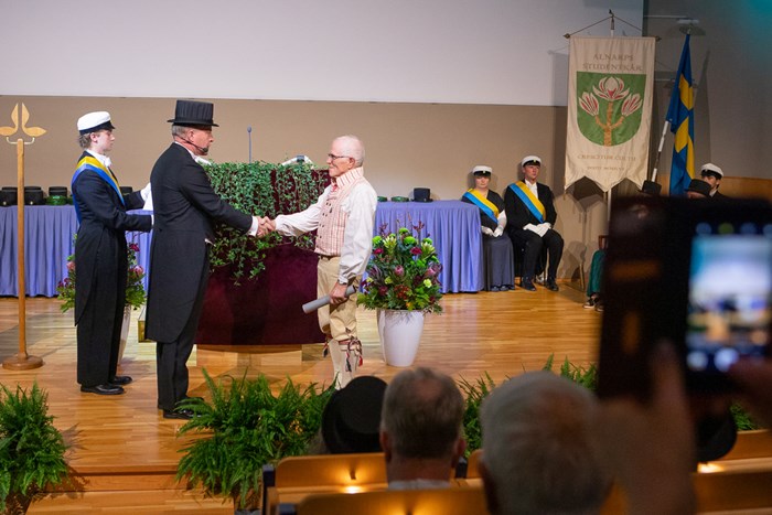 One of this year's jubilee doctors shaking hands with the promotor for the NJ Faculty .