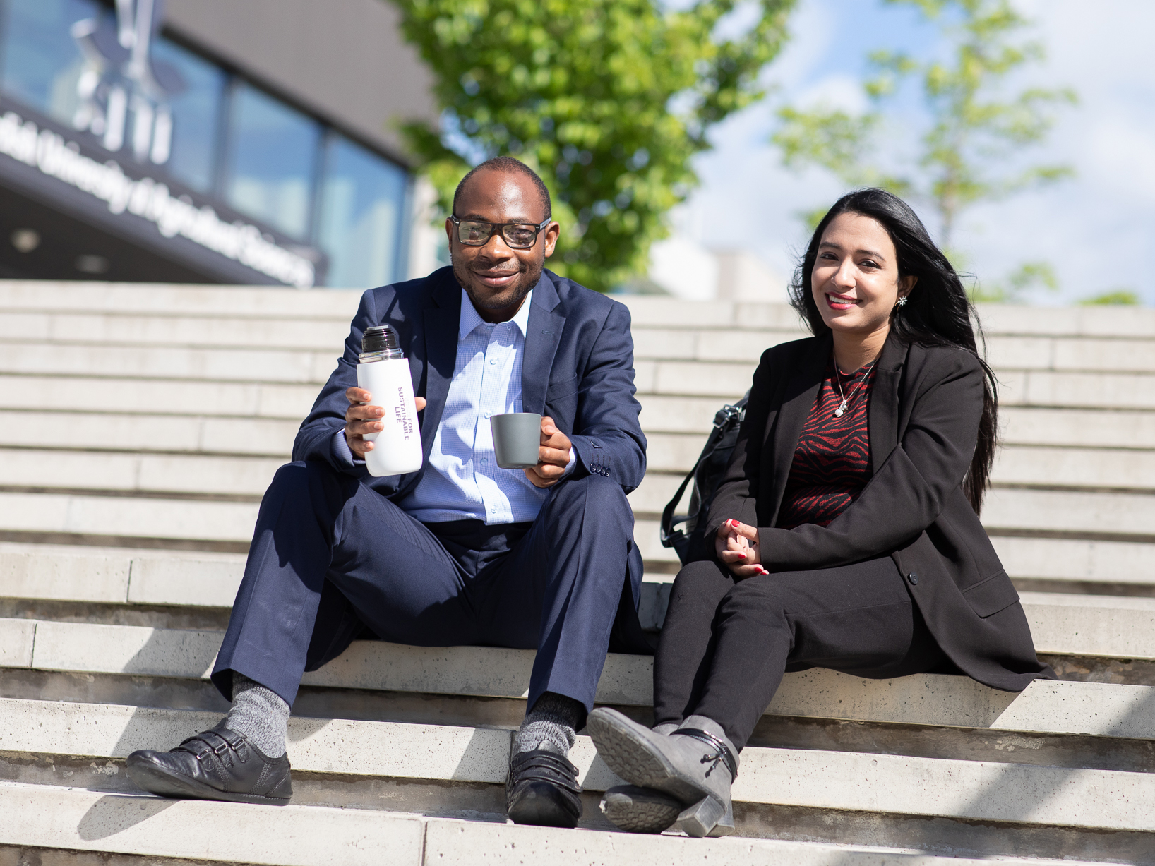 Two students sitting on stairs. Photo.