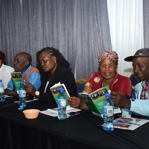 People sitting at a table reading a folder