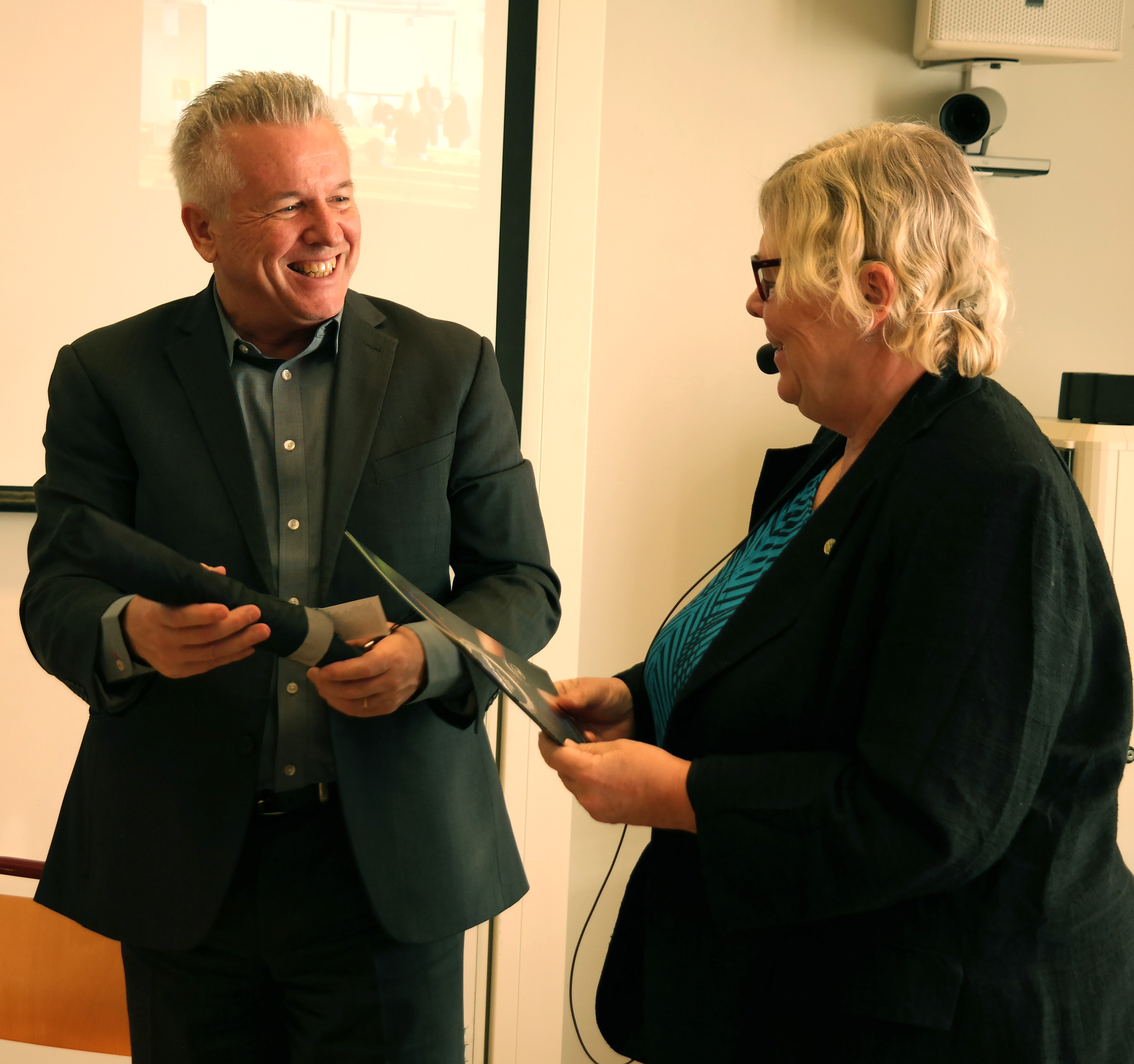 Man and woman in a room laughing together. Photo.