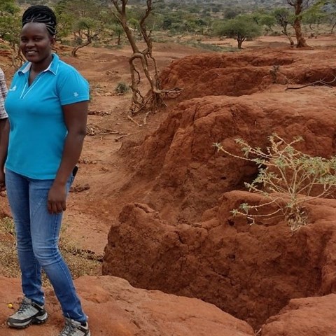 Kenyan woman standing in an eroded landscape in Kenya