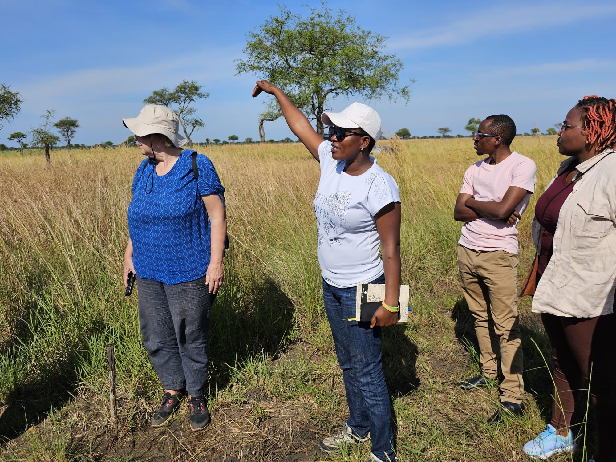 Woman showing to group in grassland