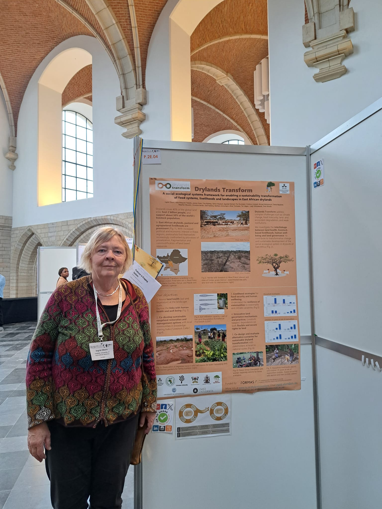 Woman standing next to a poster.