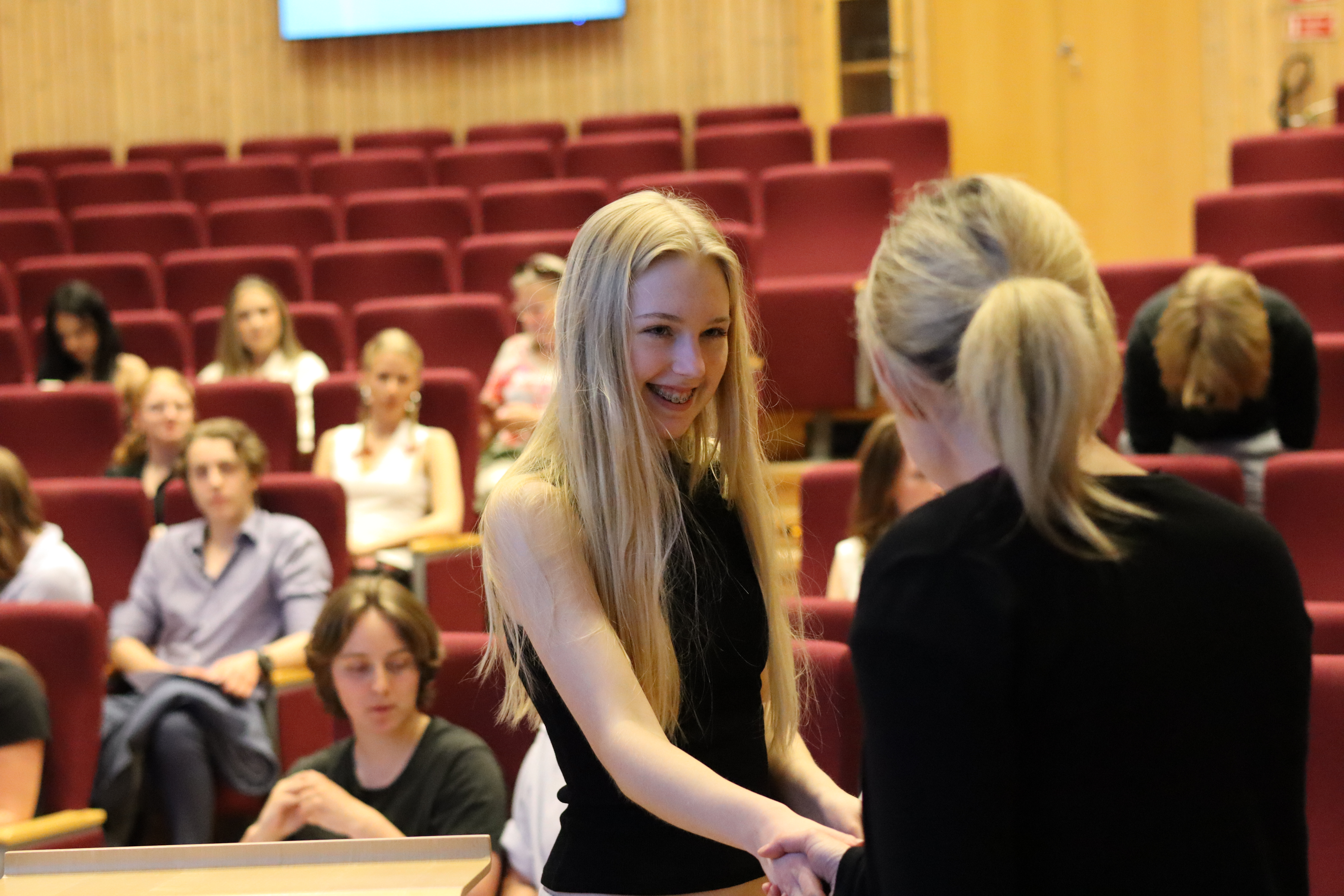 En kvinnlig gymnasieelev får diplom