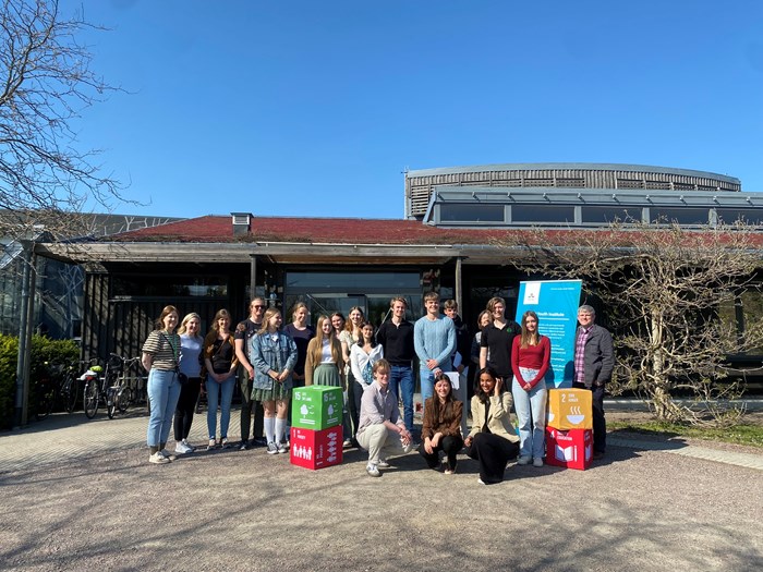 Gruppbild med SDG-kuber framför hus