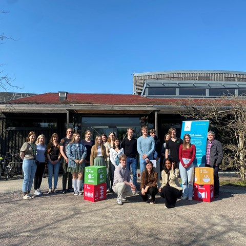 Gruppbild med SDG-kuber framför hus
