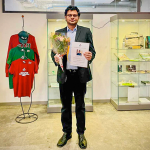 En man med blommor och diplom. Foto.