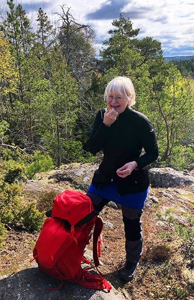 Porträttbild på Tuija Hilding Rydevik, på tur i naturskönt landskap. Foto. 