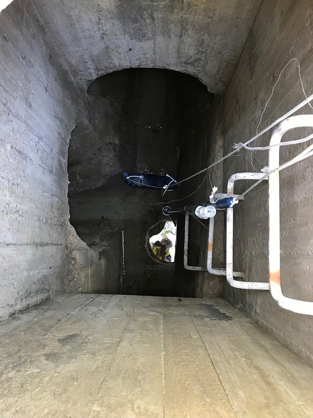 Öppen dagvattenbrunn med en stege och provtagningsutrustning, foto.