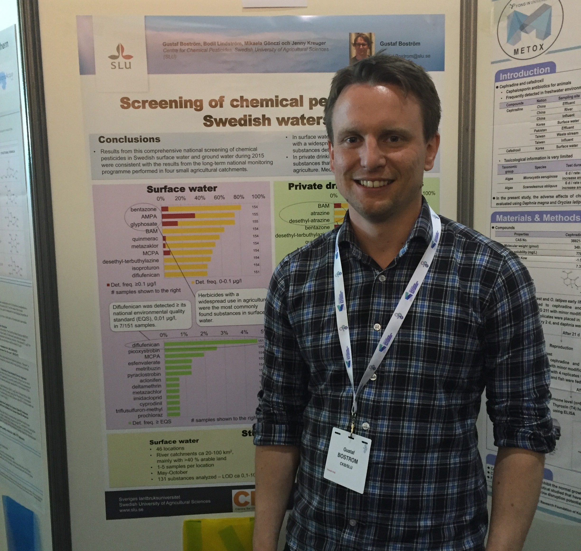 Man framför en vetenskaplig poster, foto.