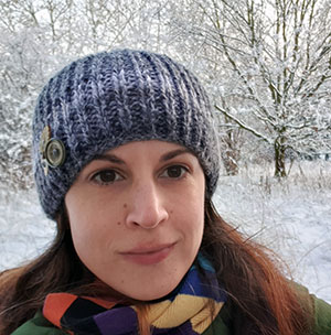 Porträtt av Cat Scott i ett snölandskap med träd i bakgrunden. Foto.