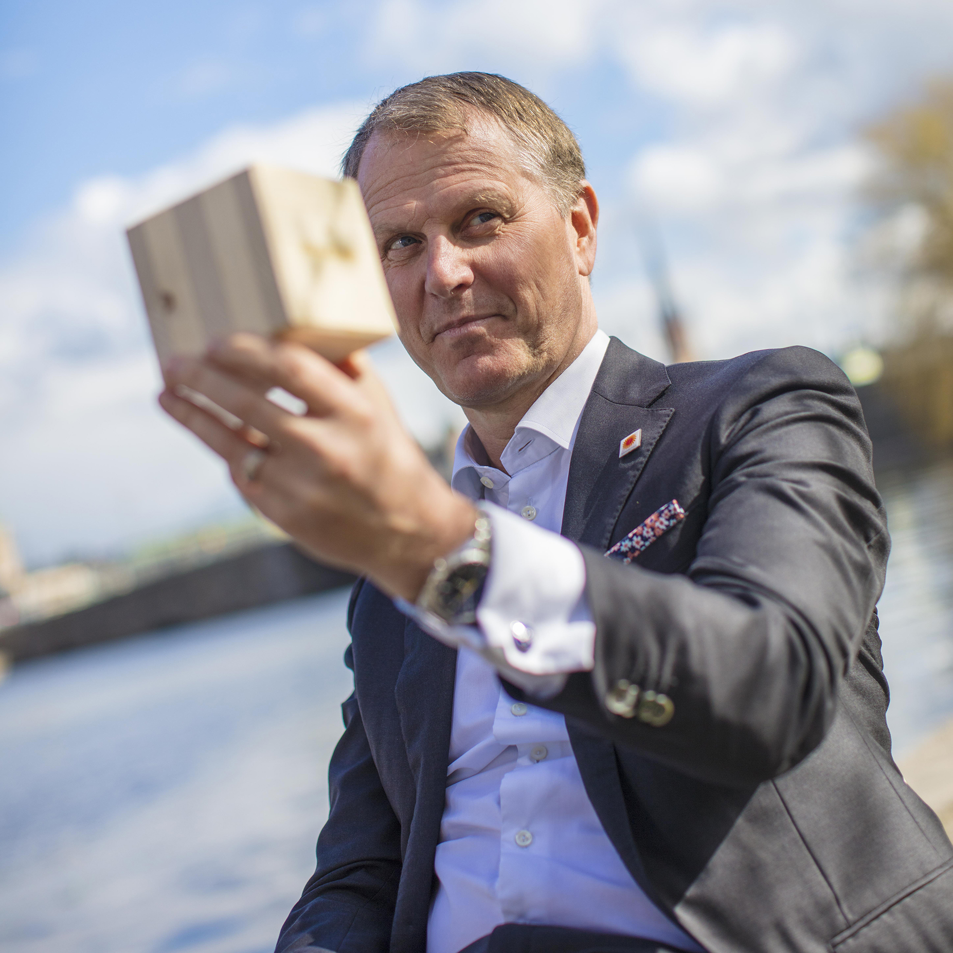 Per Lyrvall, Sverigechef på Stora Enso visar upp en kub av korslimmat trä.