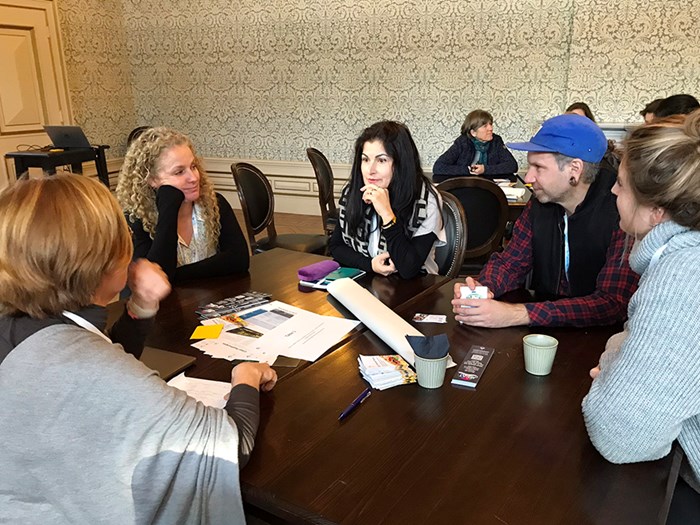 Group of people in conversation around a table.