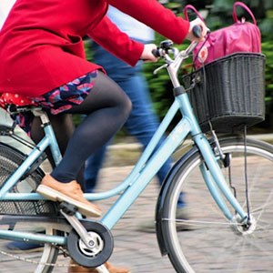 En kvinna som cyklar i staden. Foto.