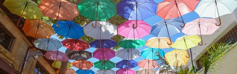 Colourful umbrellas hanging over a street.