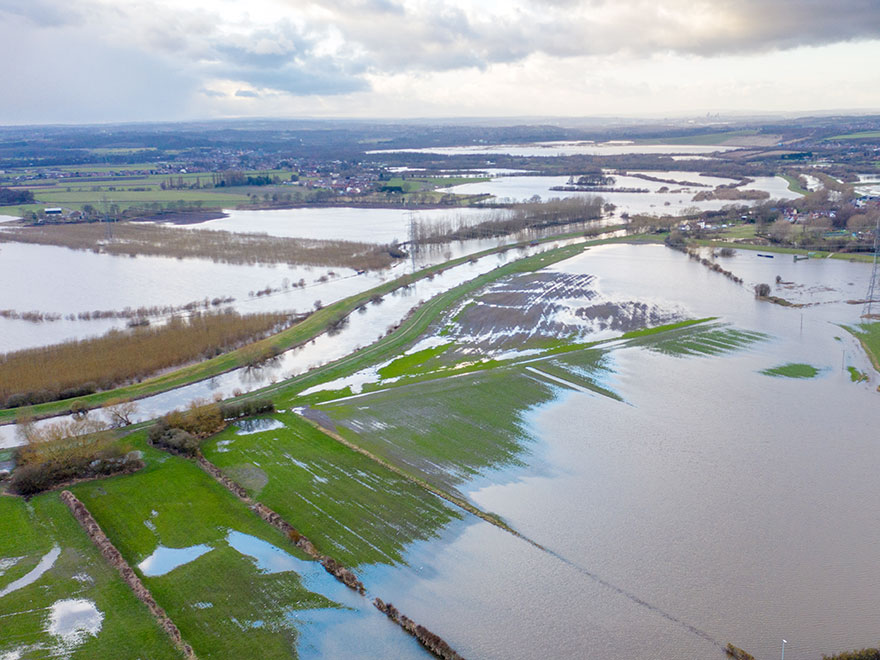 Drönarflygbild över översvämmade jordbruksfält.