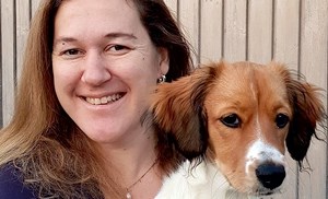 En glad kvinna och en hund, foto.