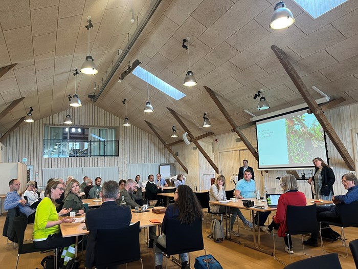 Ett trettiotal workshopdeltagare lyssnar på en av deltagarna på workshopen Växtförädling och Äpple den 9 maj 2022.