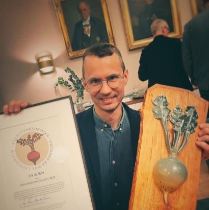 Erik de Vahl håller i diplom och en statyett föreställande en kålrot. 