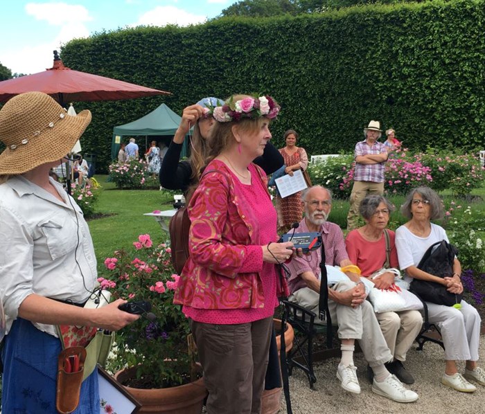 Maria Axelsson från Fredriksdal fäster rosenkransen på Helena Perssons huvud.