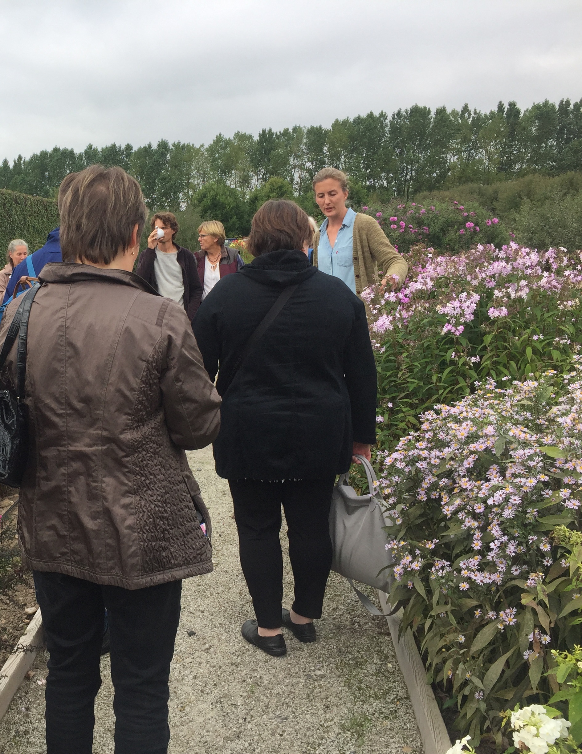 Färgfoto som visar en grupp besökare i Nationella genbanken. Besökarna lyssnar på presentation av växterna i genbanken.