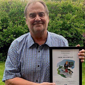 Erik Degerman håller i ett diplom. Foto.