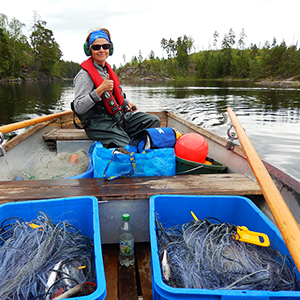 Kvinna kör båt i sjö. Foto.