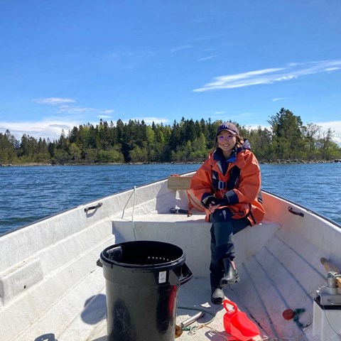 Kvinna som sitter i fören på en båt