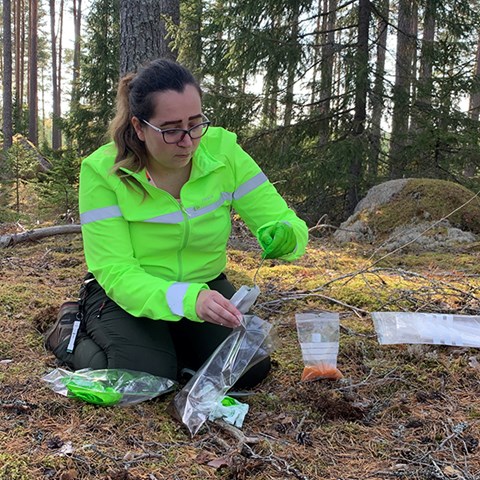 Kvinna tar jordprov.