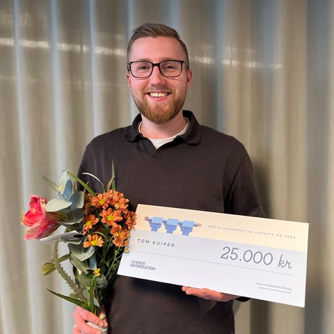 Studenten Tom Kuiper står med sitt pris för bästa uppsats