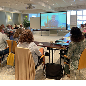 Vy över 10-tal personer som ser på en skärm