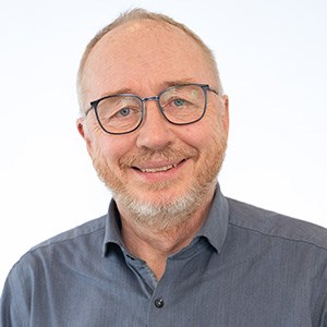 Man med glasögon, grått hår och skägg