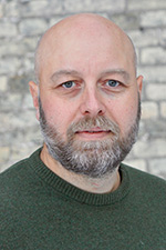 Man med kal hjässa och mörkt skägg