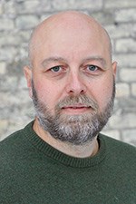 Man med kal hjässa och mörkt skägg