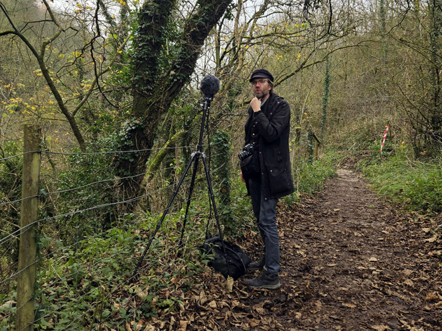 En man i en skog med en mikrofon
