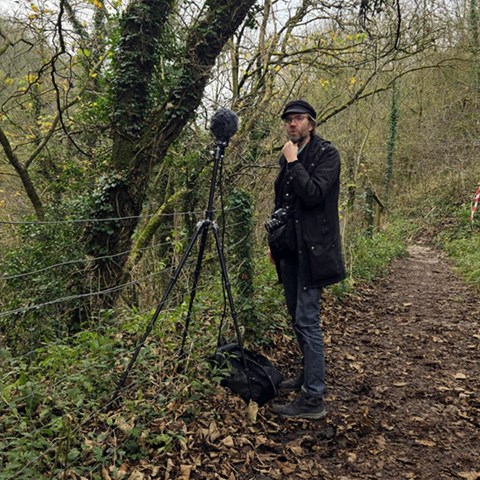 En man i en skog med en mikrofon
