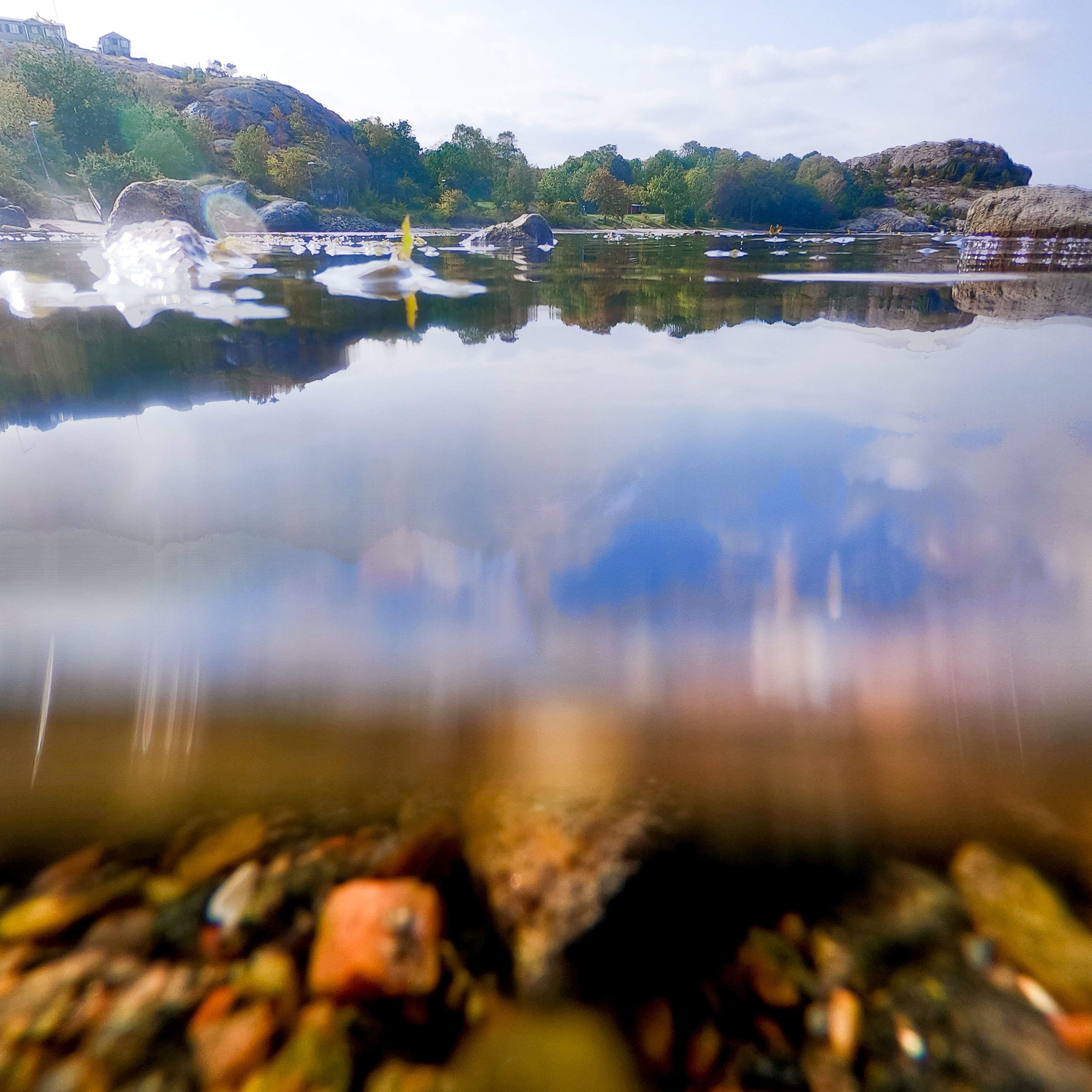vattenyta. Himmel och bebyggelse i övre delen av bilden.  Sjö i nedre delen av bilden.