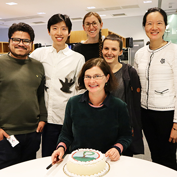 six people in front of a table. portrait.