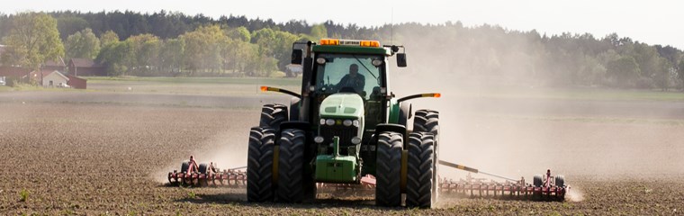 En traktor plöjer ett fält, foto.