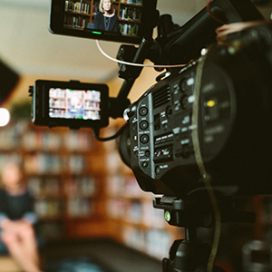 filmkamera med kvinna i bakgrunden