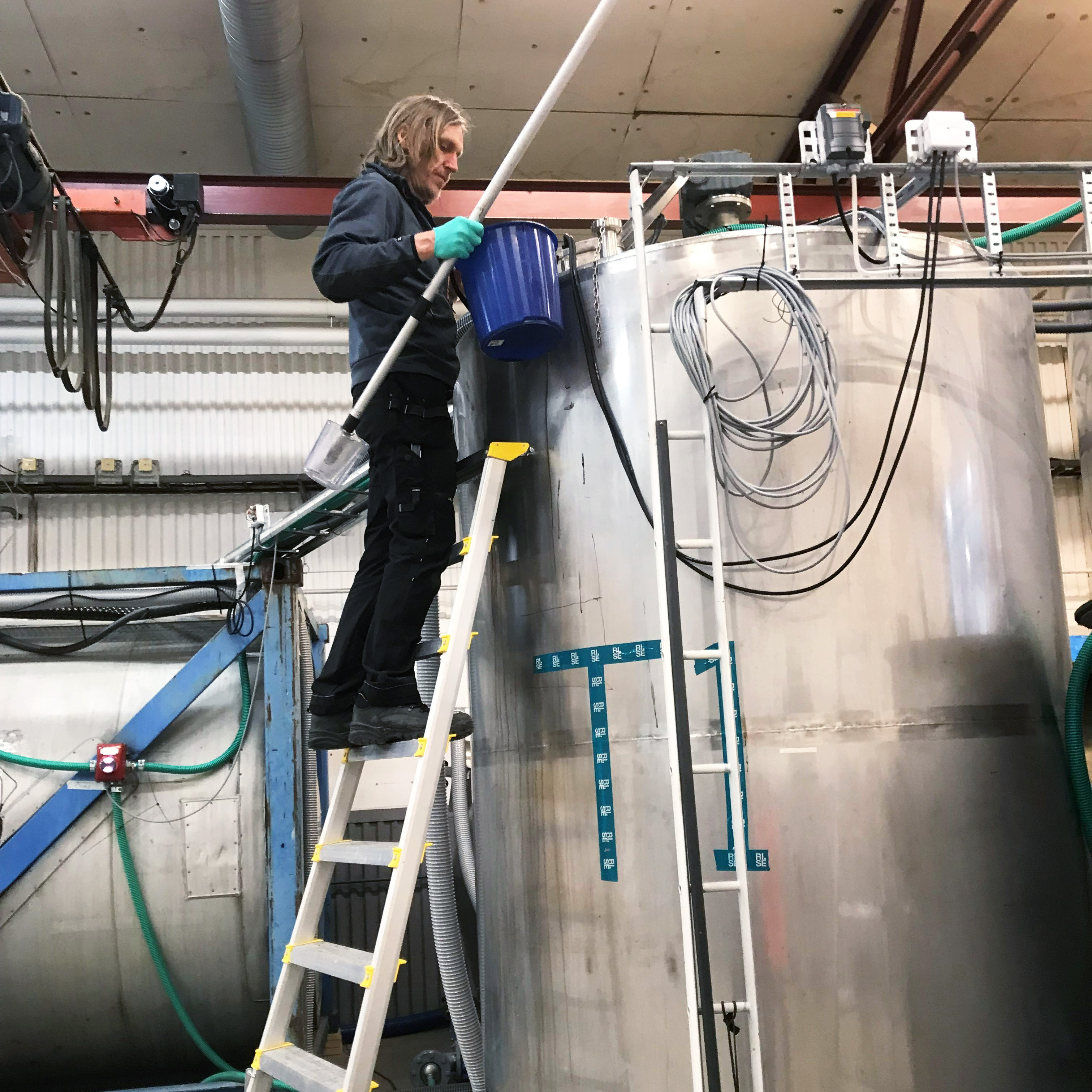 En man står vid en tank och arbetar