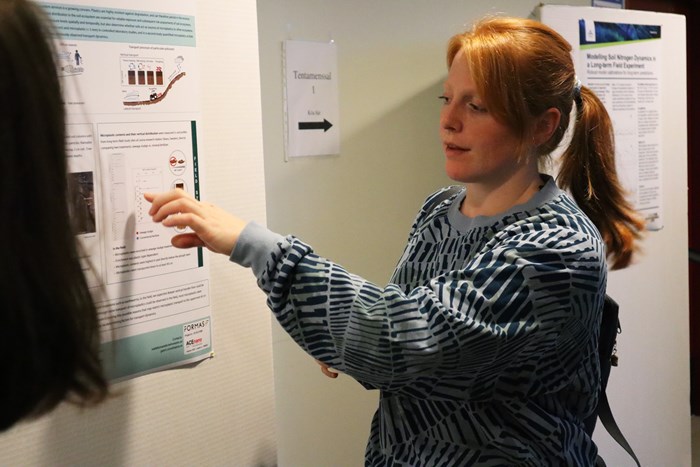 En kvinna pekar på en poster av ett forskningsprojekt