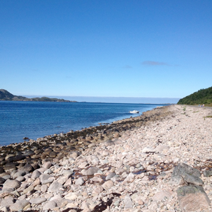 An ocean shore with pebbles. Photo.