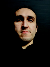 Portrait photo of a man against at black background. Photo.