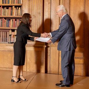 A man hand a woman shakes hand in a library. Photo.