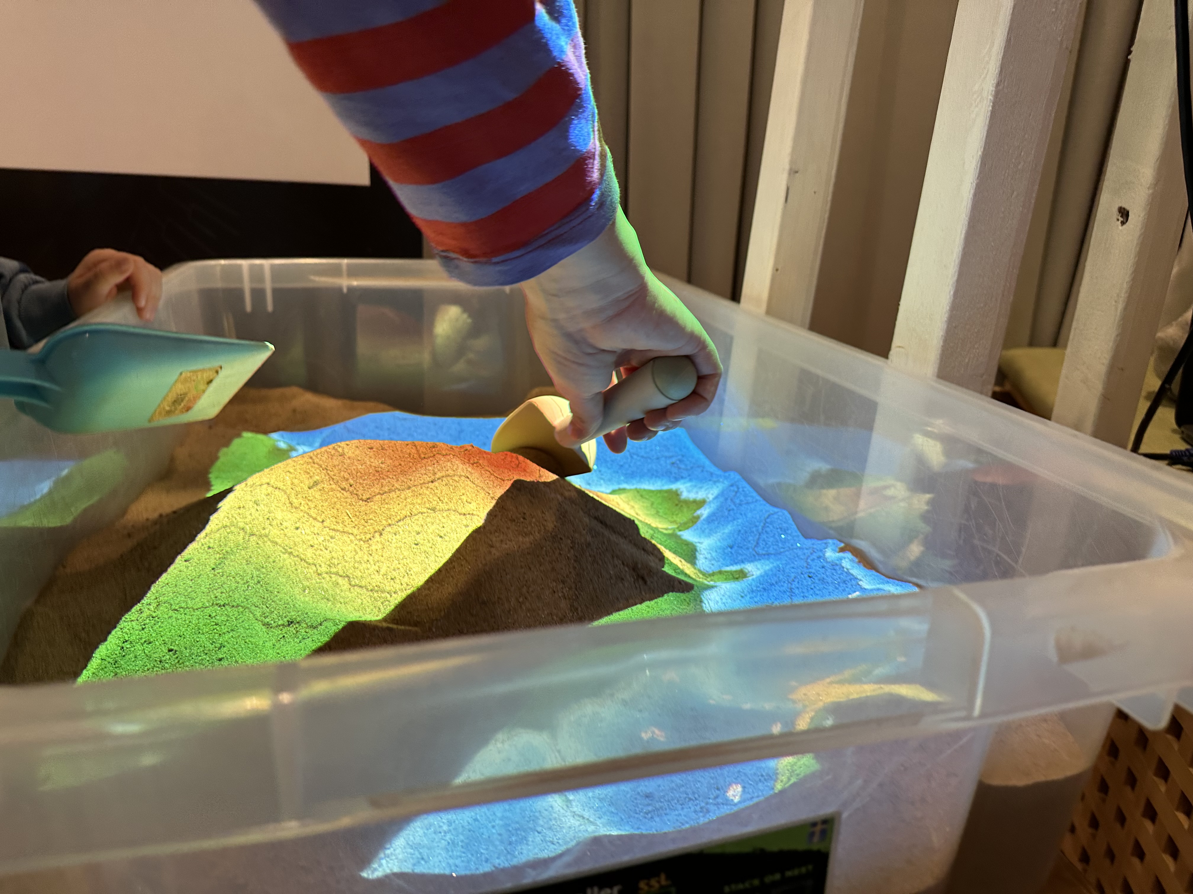 A child and an adult digging in a digital sandbox